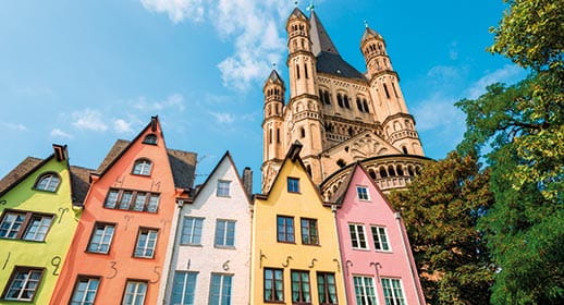 A view up towards St Martin Church in Cologne, with colourful houses in front, Germany A view up towards St Martin Church in Cologne, with colourful houses in front, Germany