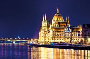 A view from the Danube River towards the Hungarian Parliament Building illuminated at night, Hungary 